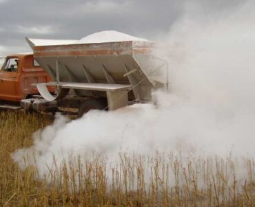 Caminhão realizando calagem em uma área para produção de grãos