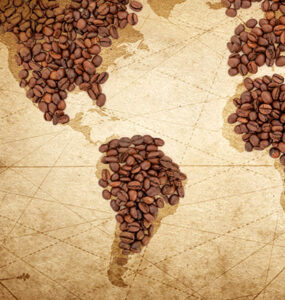 Grãos de café em cima de um mapa mundi