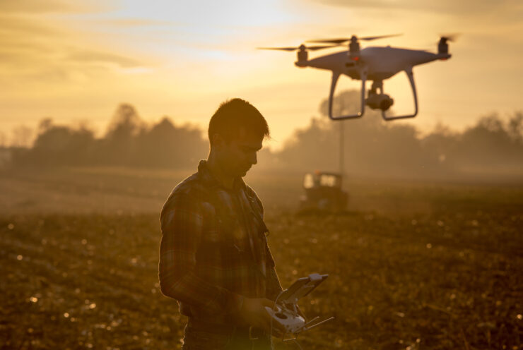 Homem pilotando um drone em uma lavoura de grãos