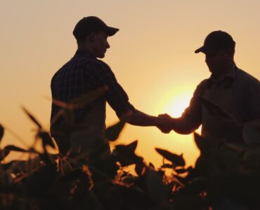Dois homens se cumprimentando em uma fazenda