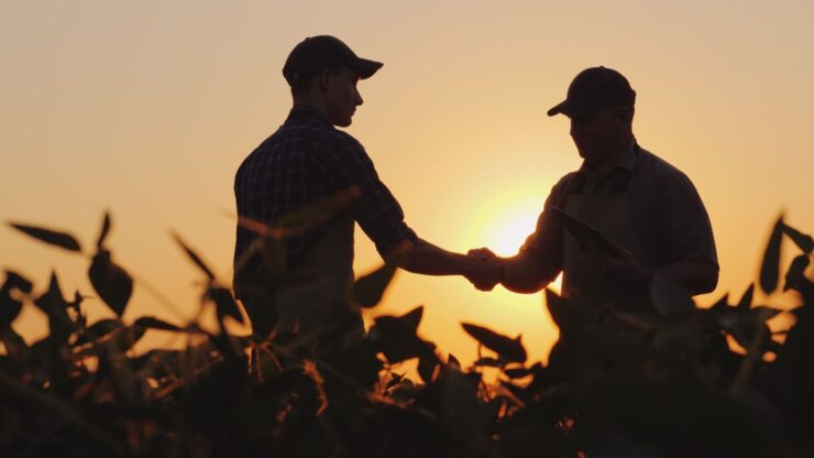 Dois homens se cumprimentando em uma fazenda