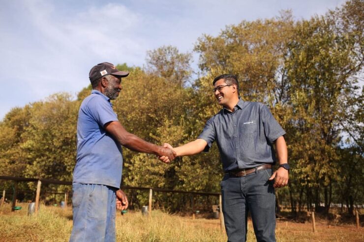 Dois homens se cumprimentando em uma fazenda